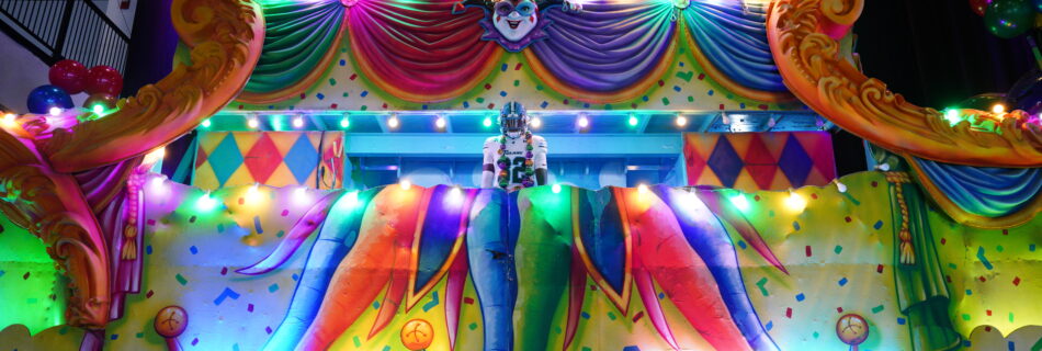A Tulane football player stands on an illuminated Mardi Gras float